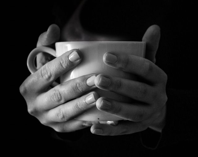 Person holding a mug of hot coffee