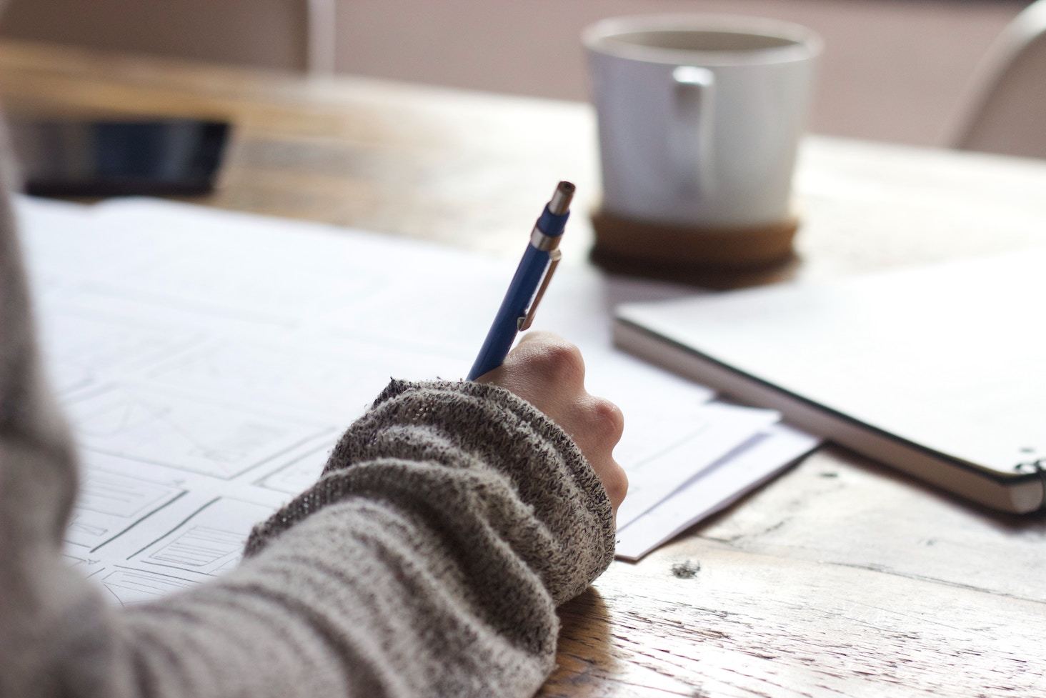 Hand holding pen at desk