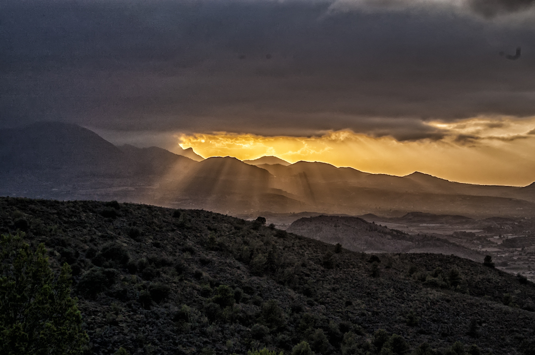 Sunrise breaking through the clouds over a mountain range
