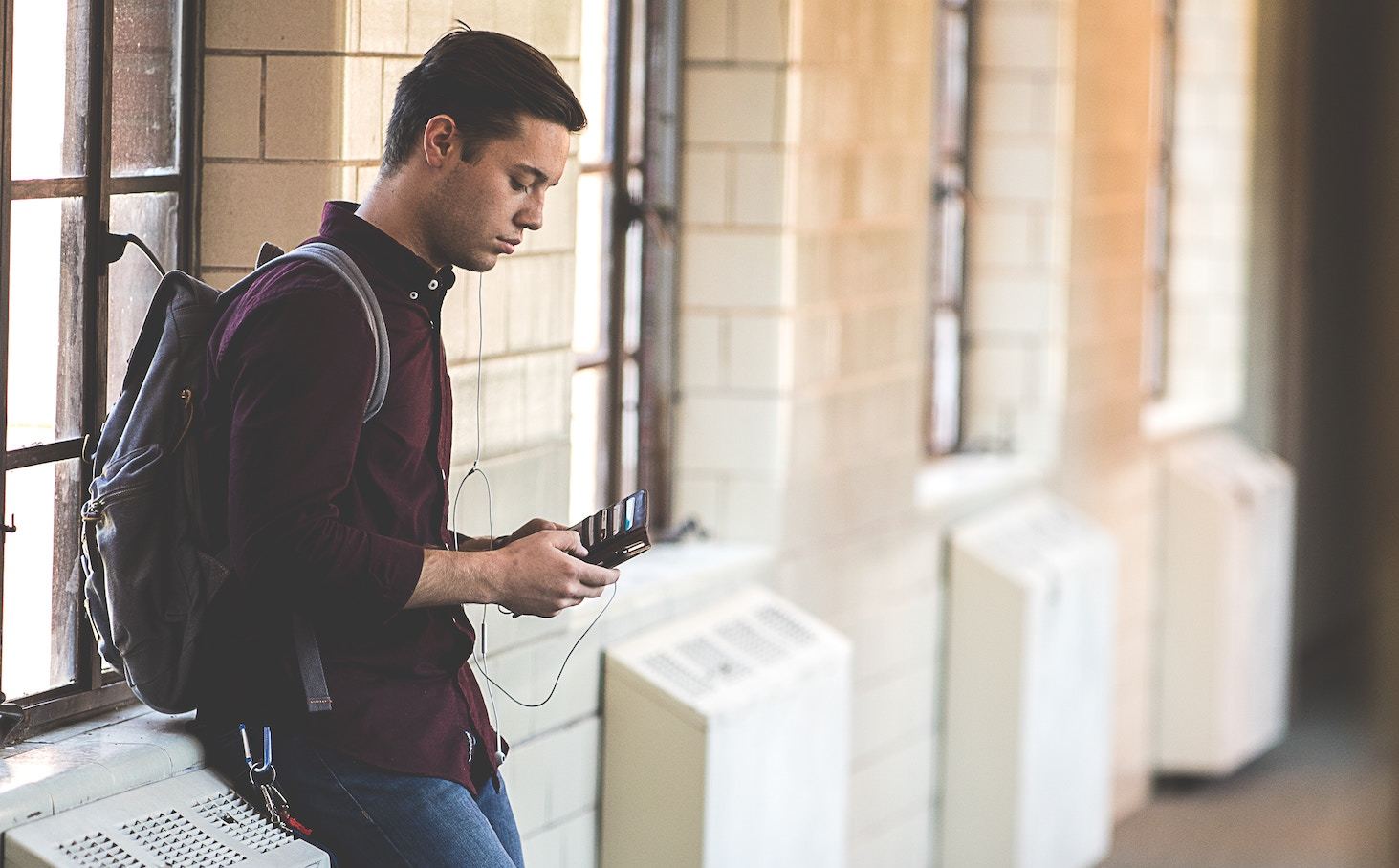 A teenager with a backpack in a school hallway