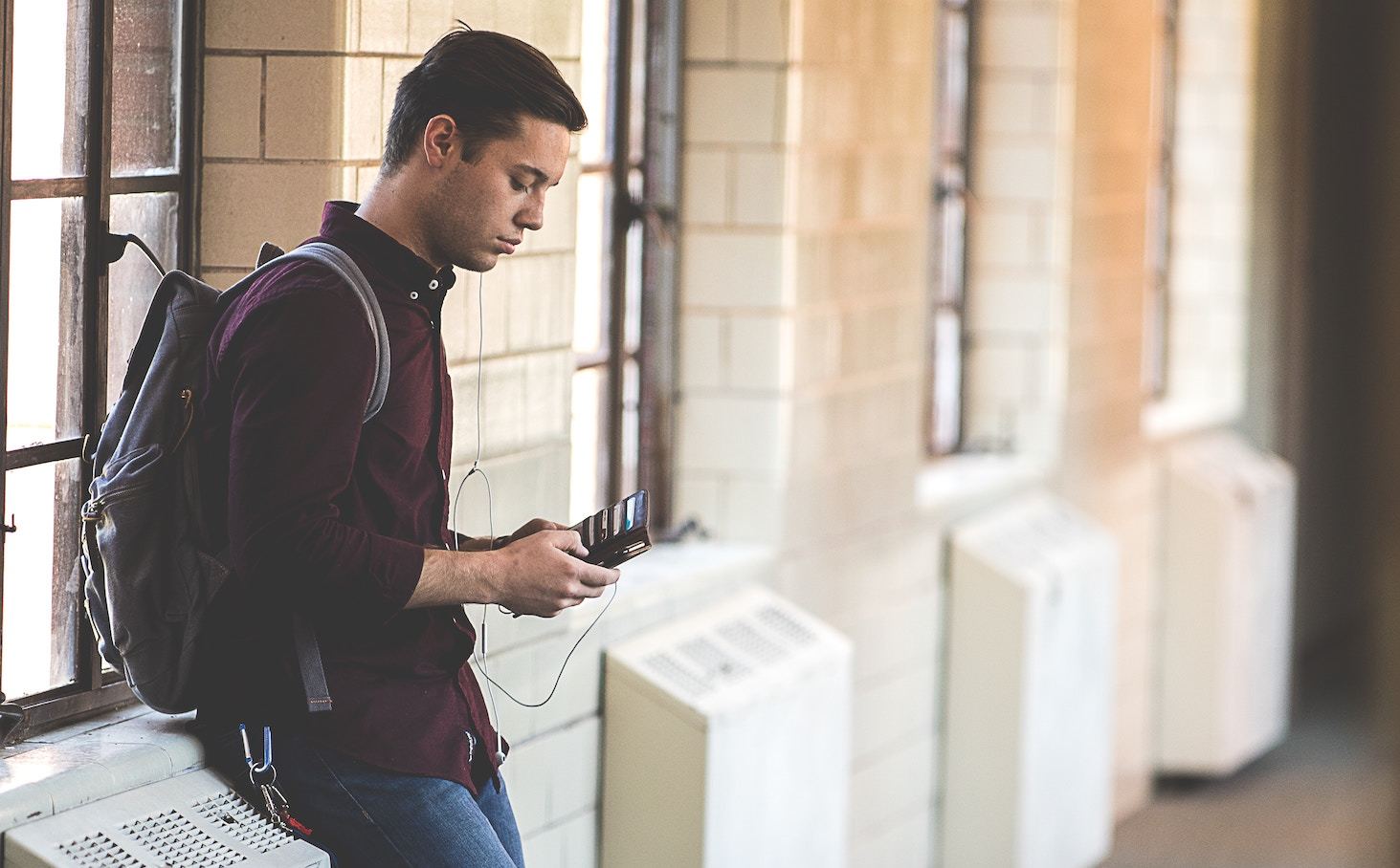 A teenager with a backpack in a school hallway