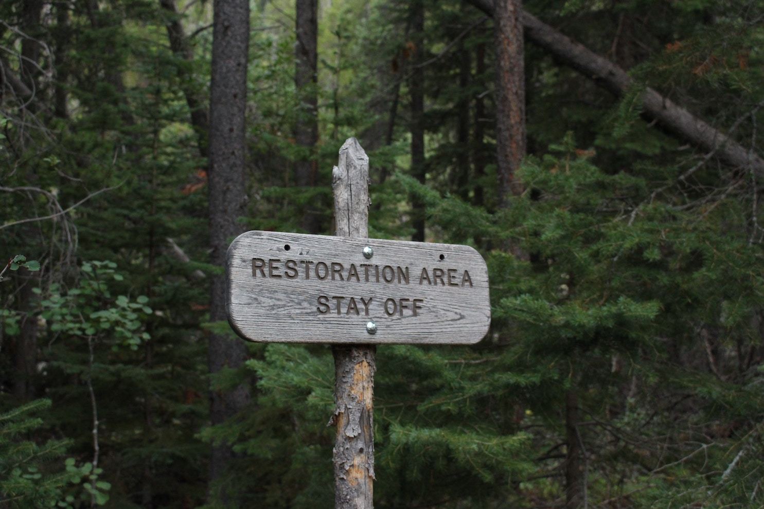 Sign in a wooded area reading 