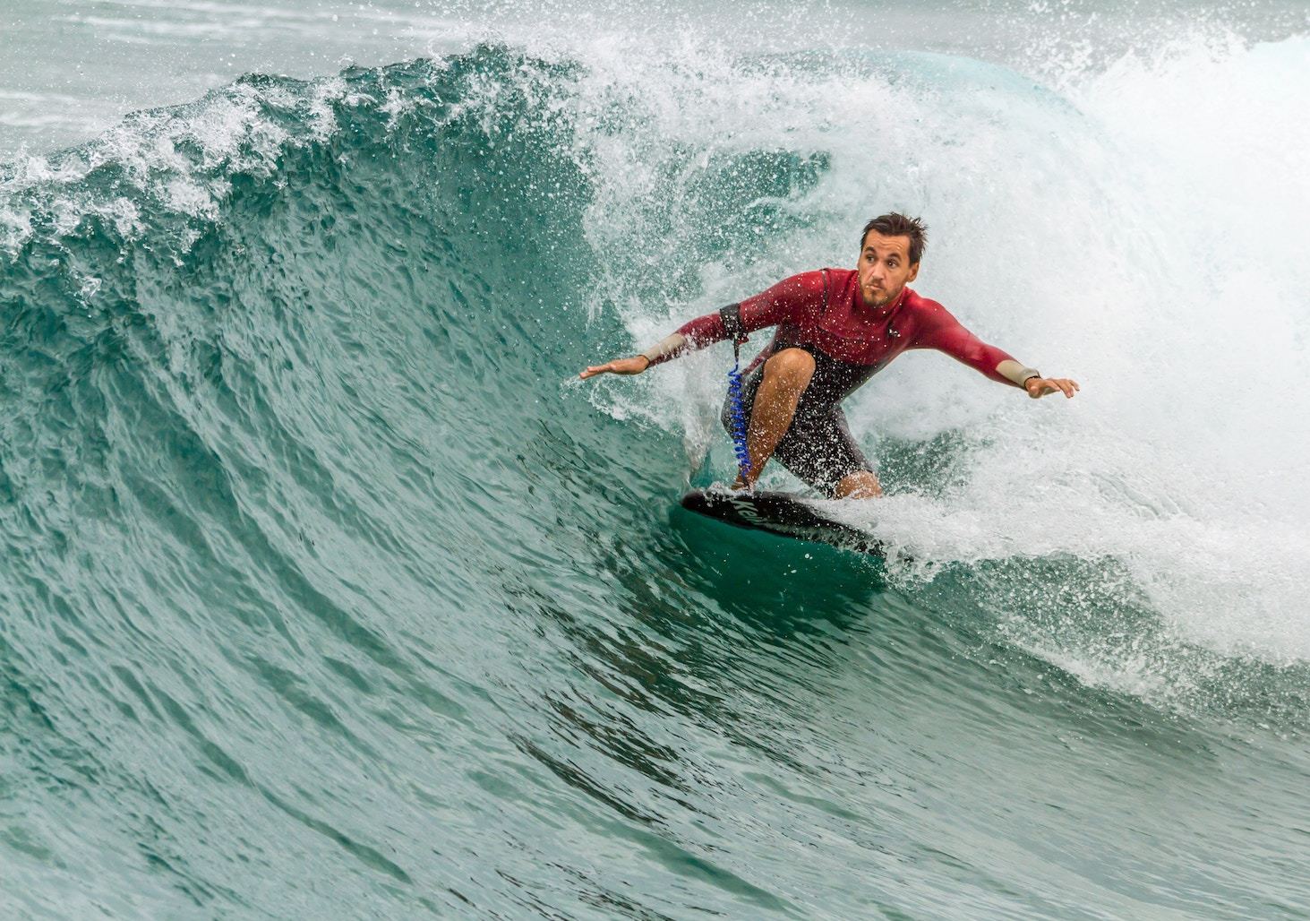 a man surfs in a red splashguard