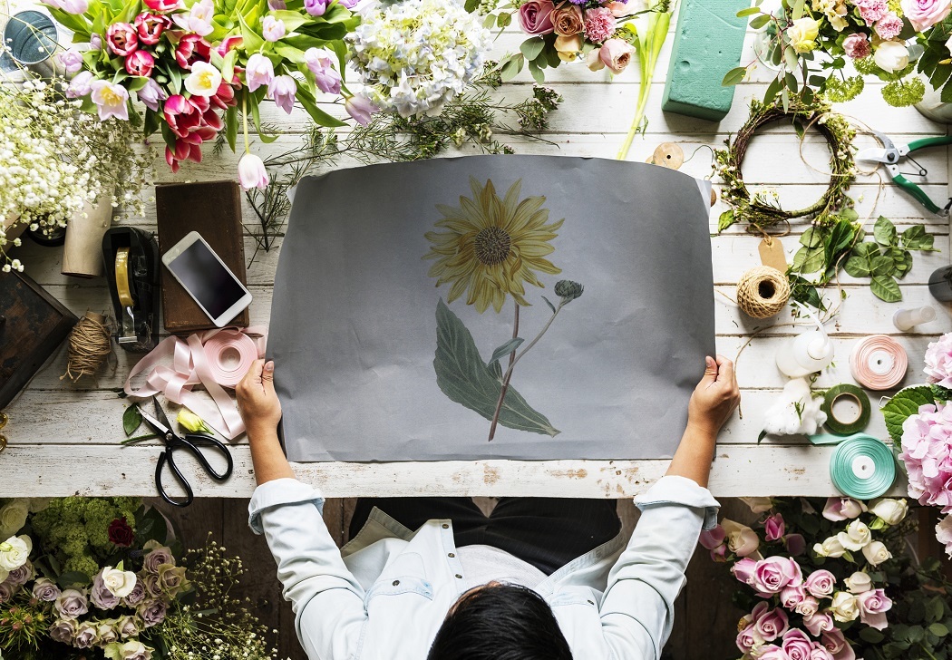 Top down shot of a person holding a large print of a sunflower