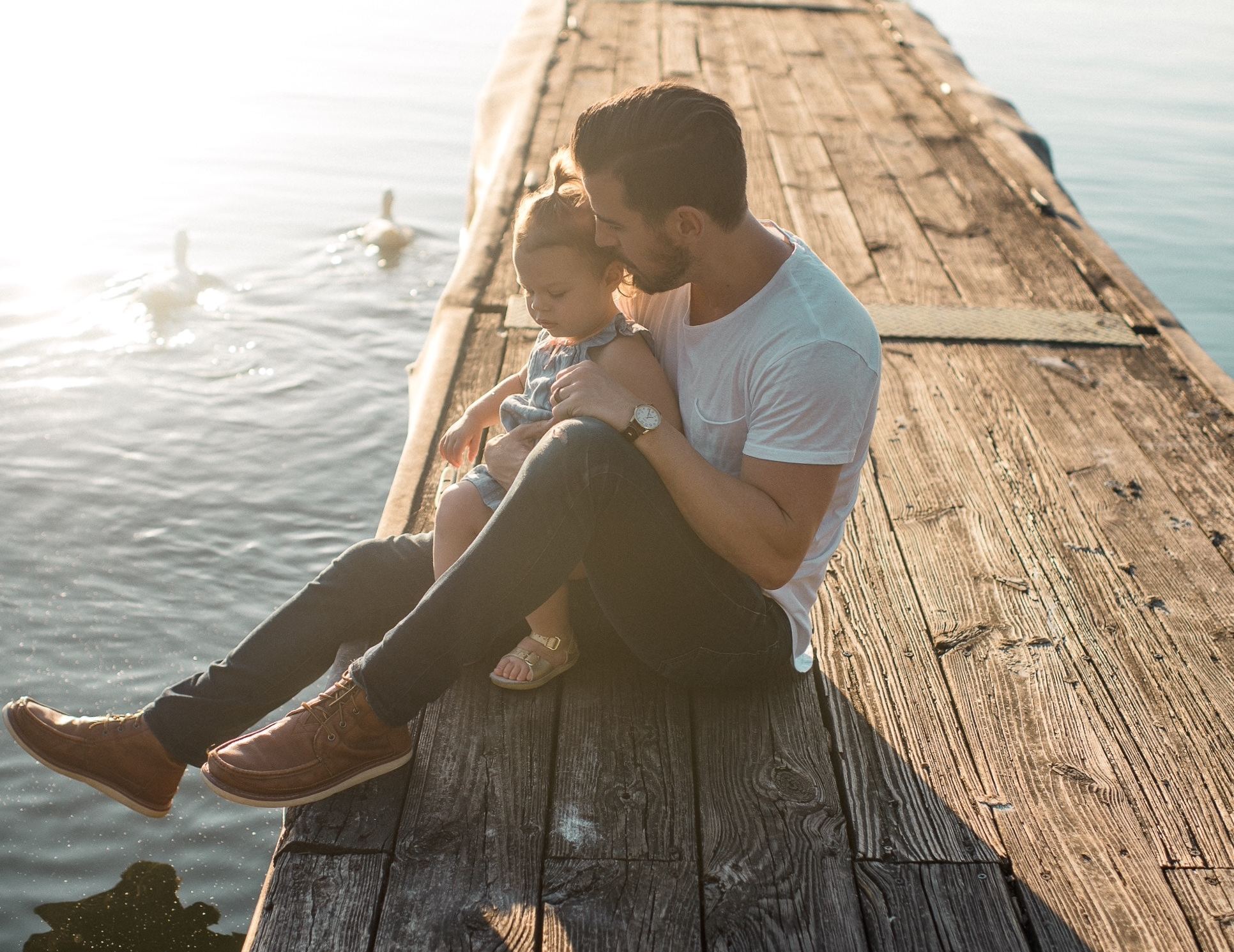 Father holding his daughter on a dock