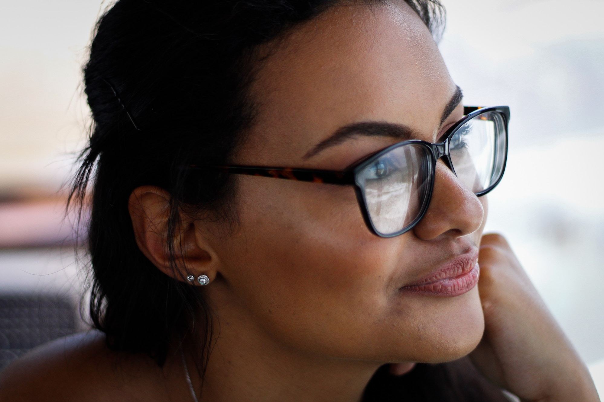 Young woman wearing glasses looks pensive