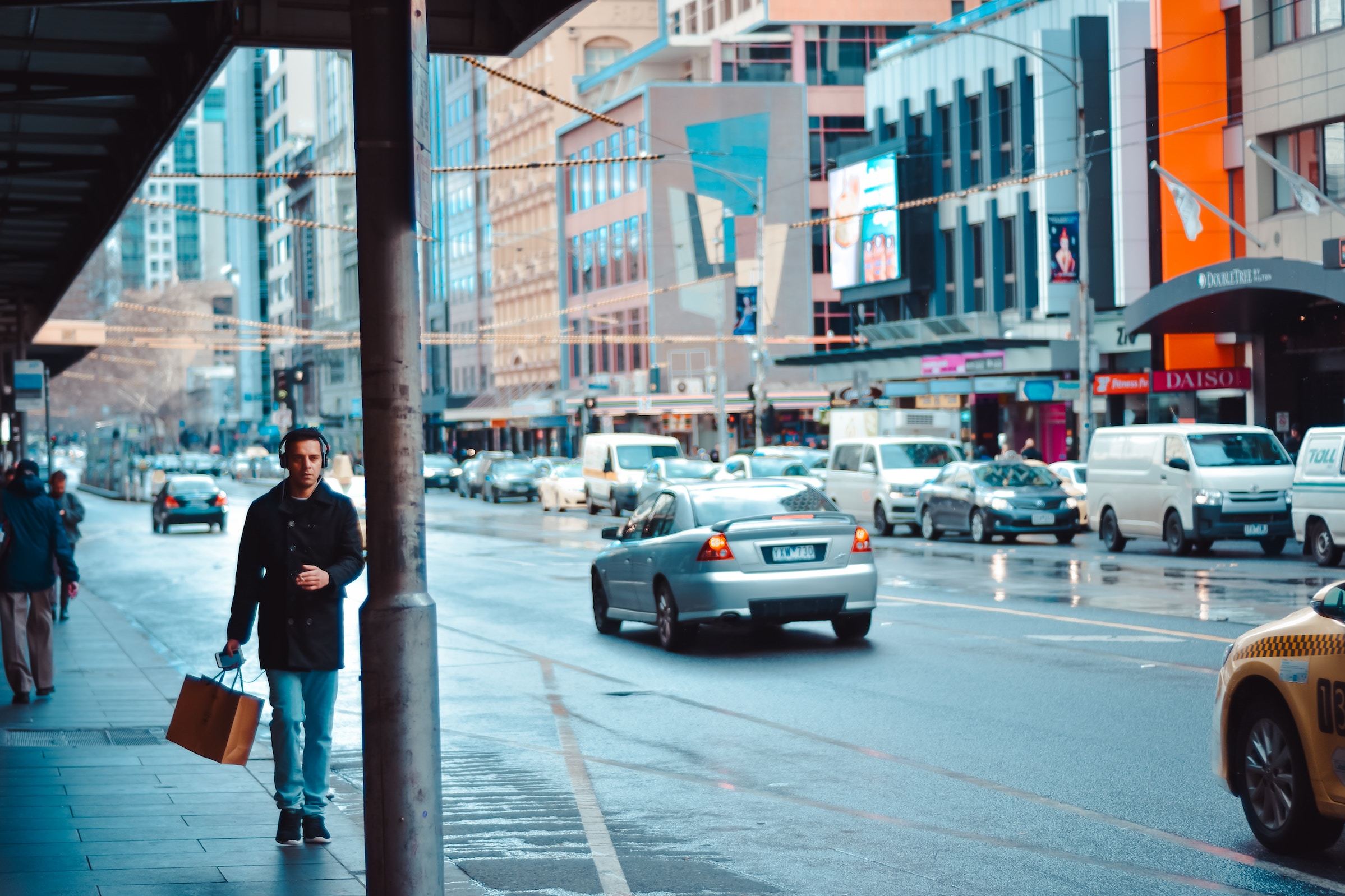 Man walking along street with shopping bag