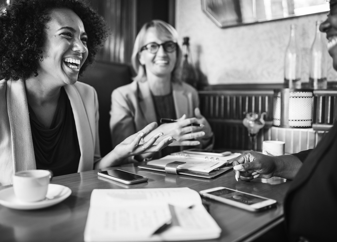 A group of professionals discussing over cups of coffee in a cafe