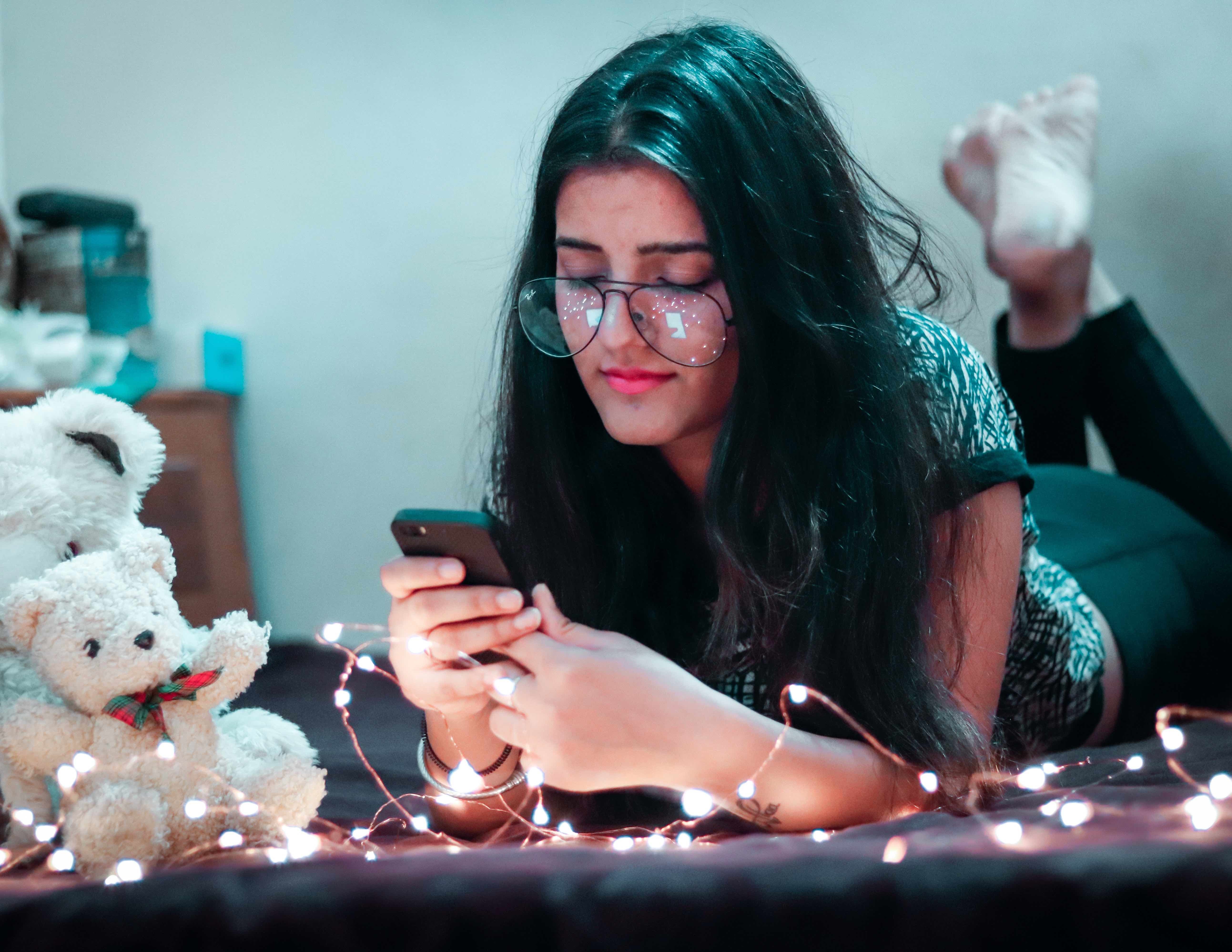 girl texting on bed