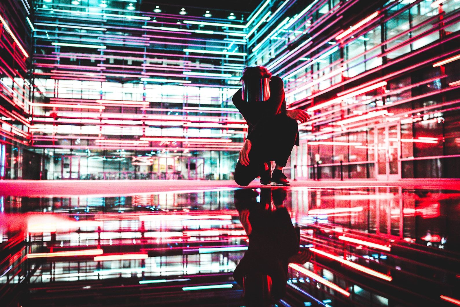 Person in black surrounded by neon