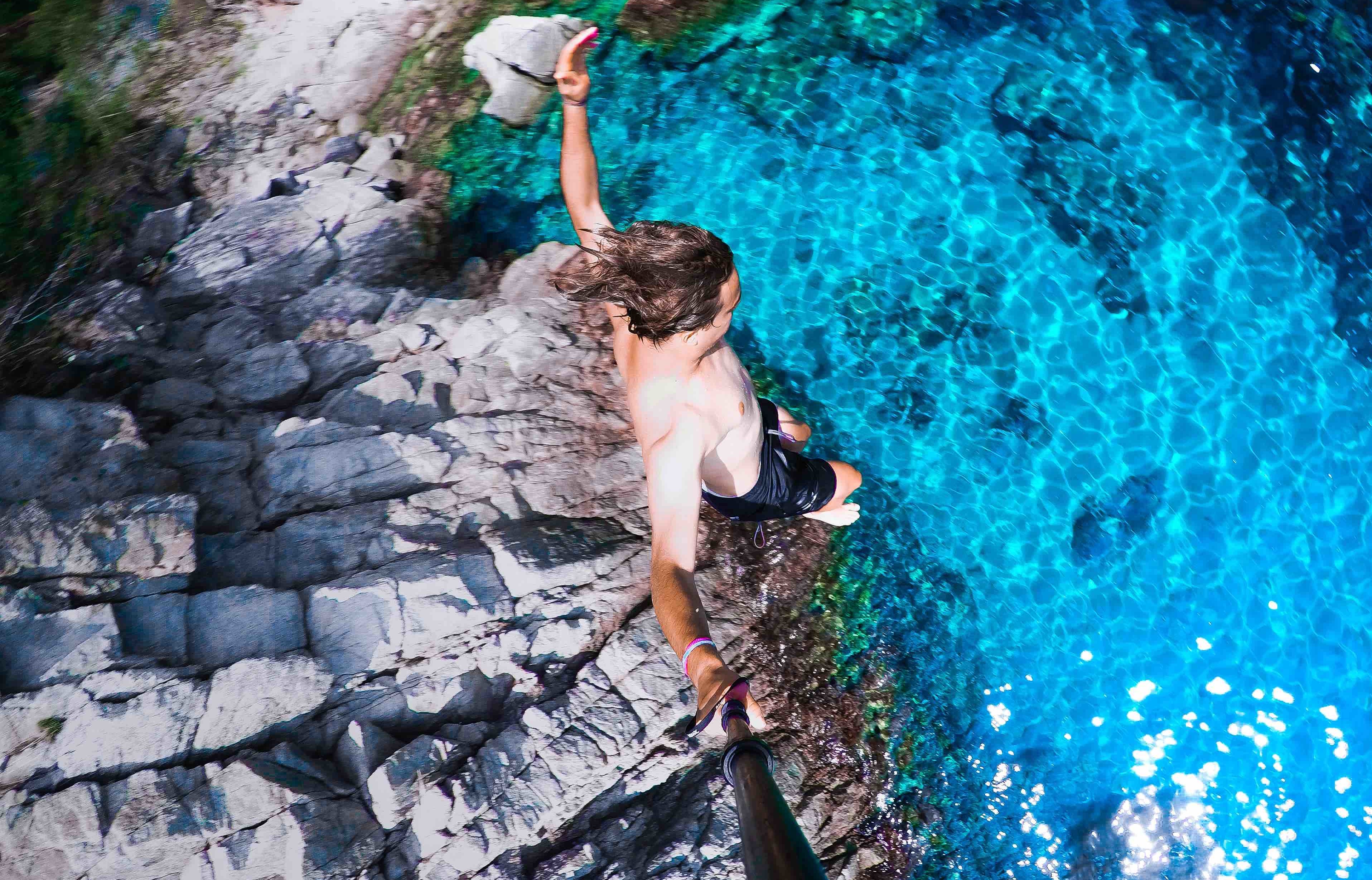 man jumping off cliff