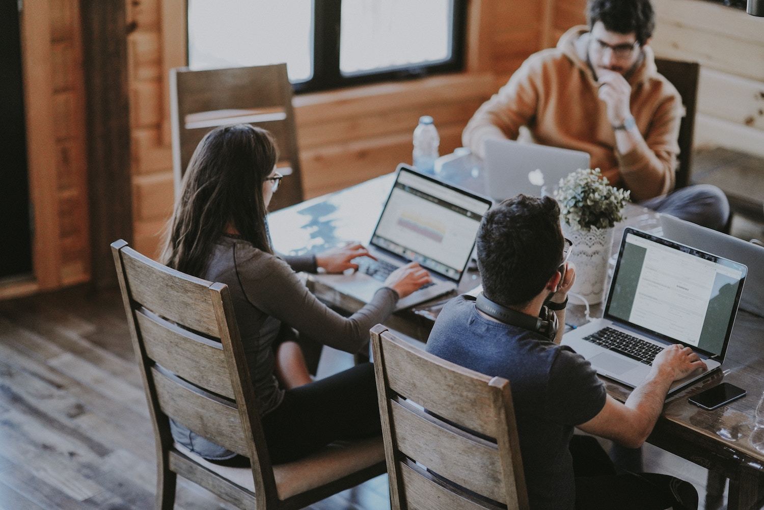 three young professionals work around a wooden table