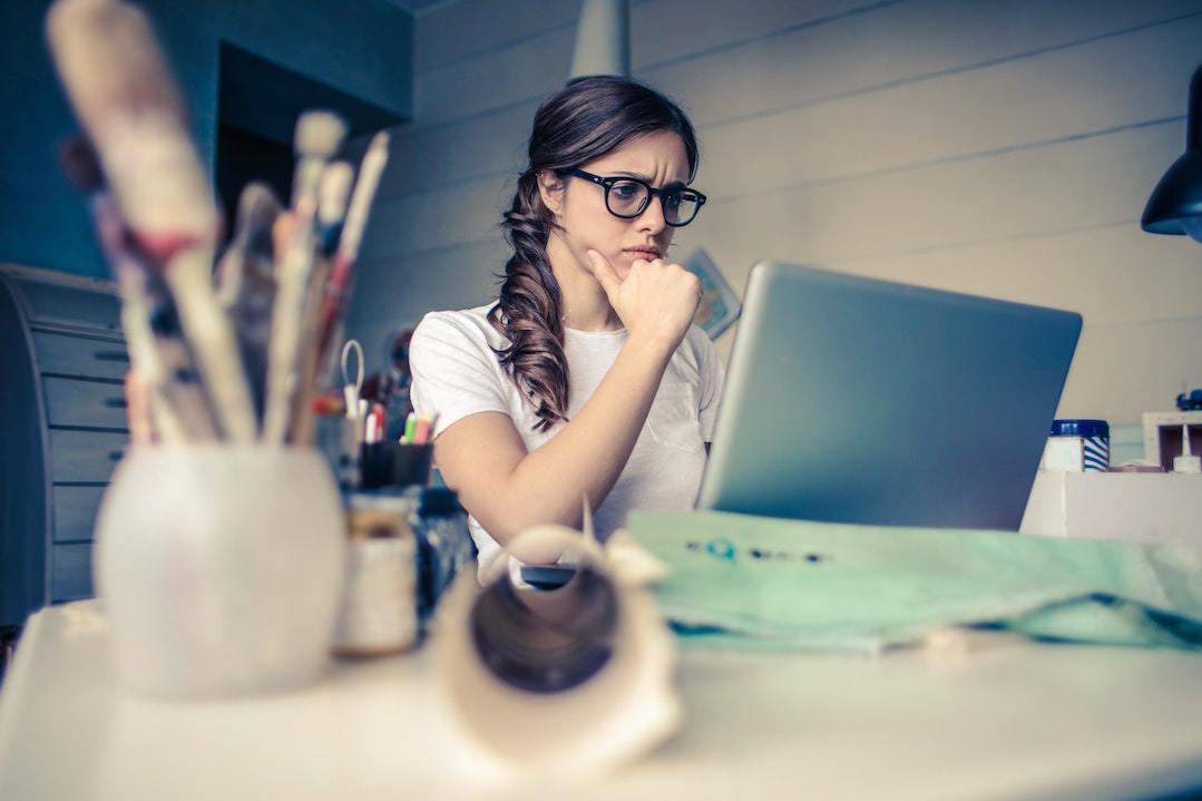 A creative thinks while looking at her computer