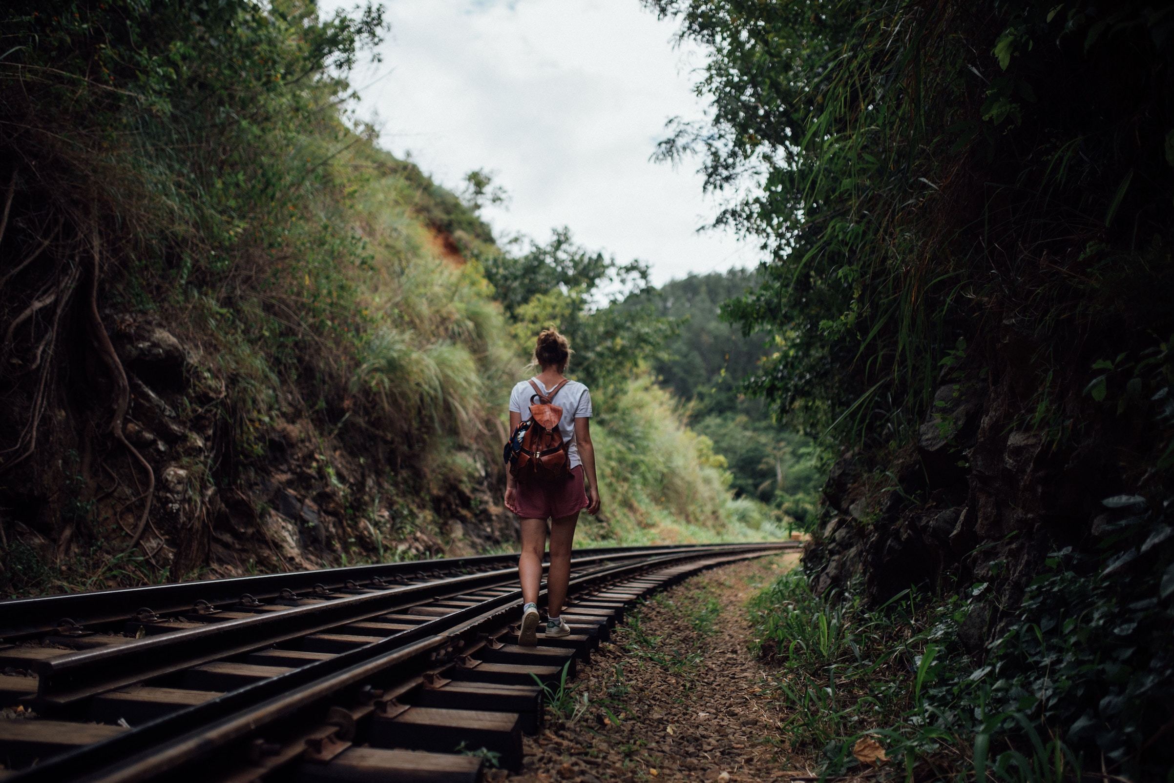 Woman walking along rural train tracks