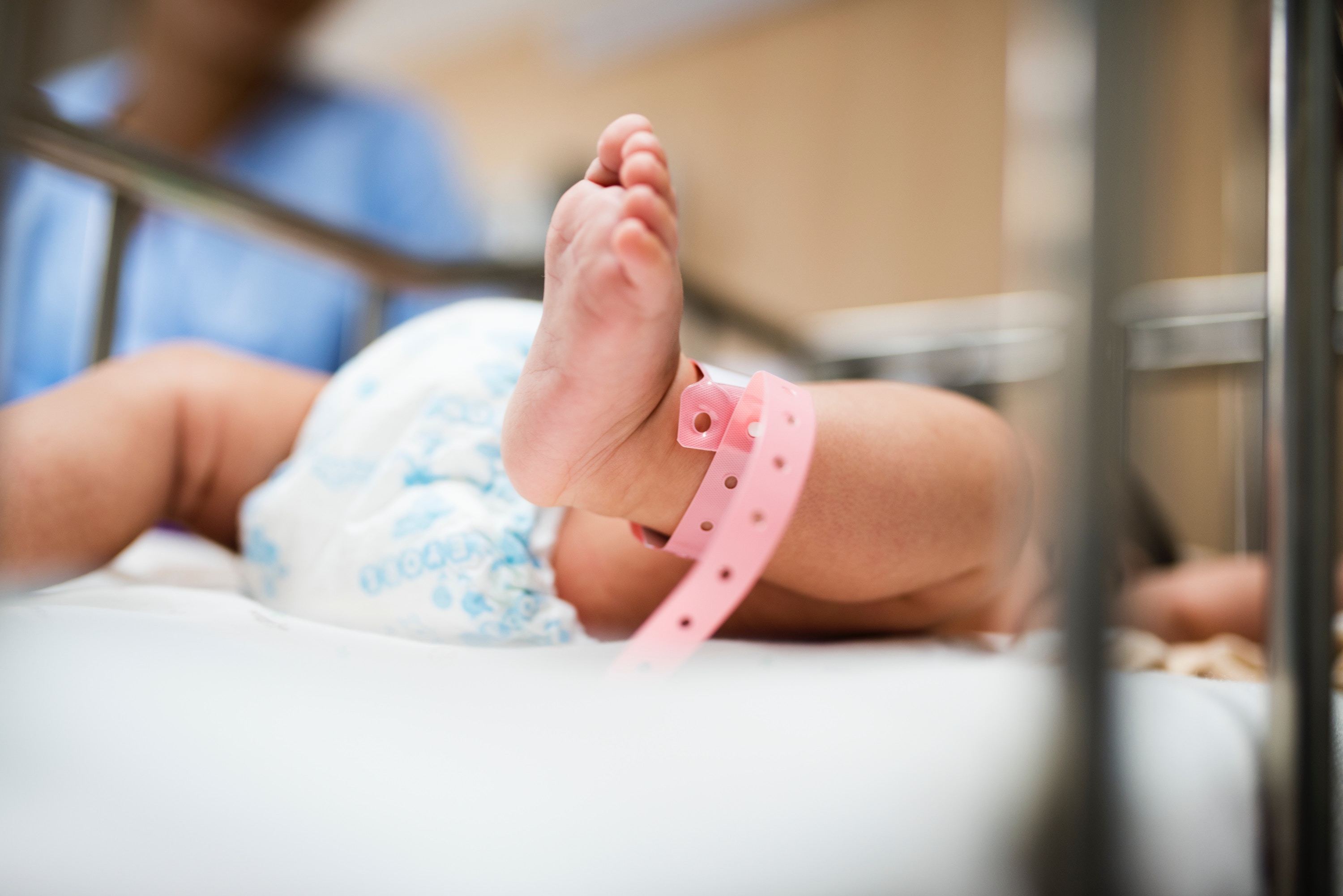 Newborn baby's foot with hospital tag