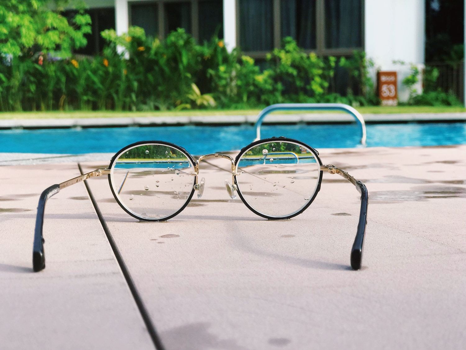 pair of glasses in front of pool