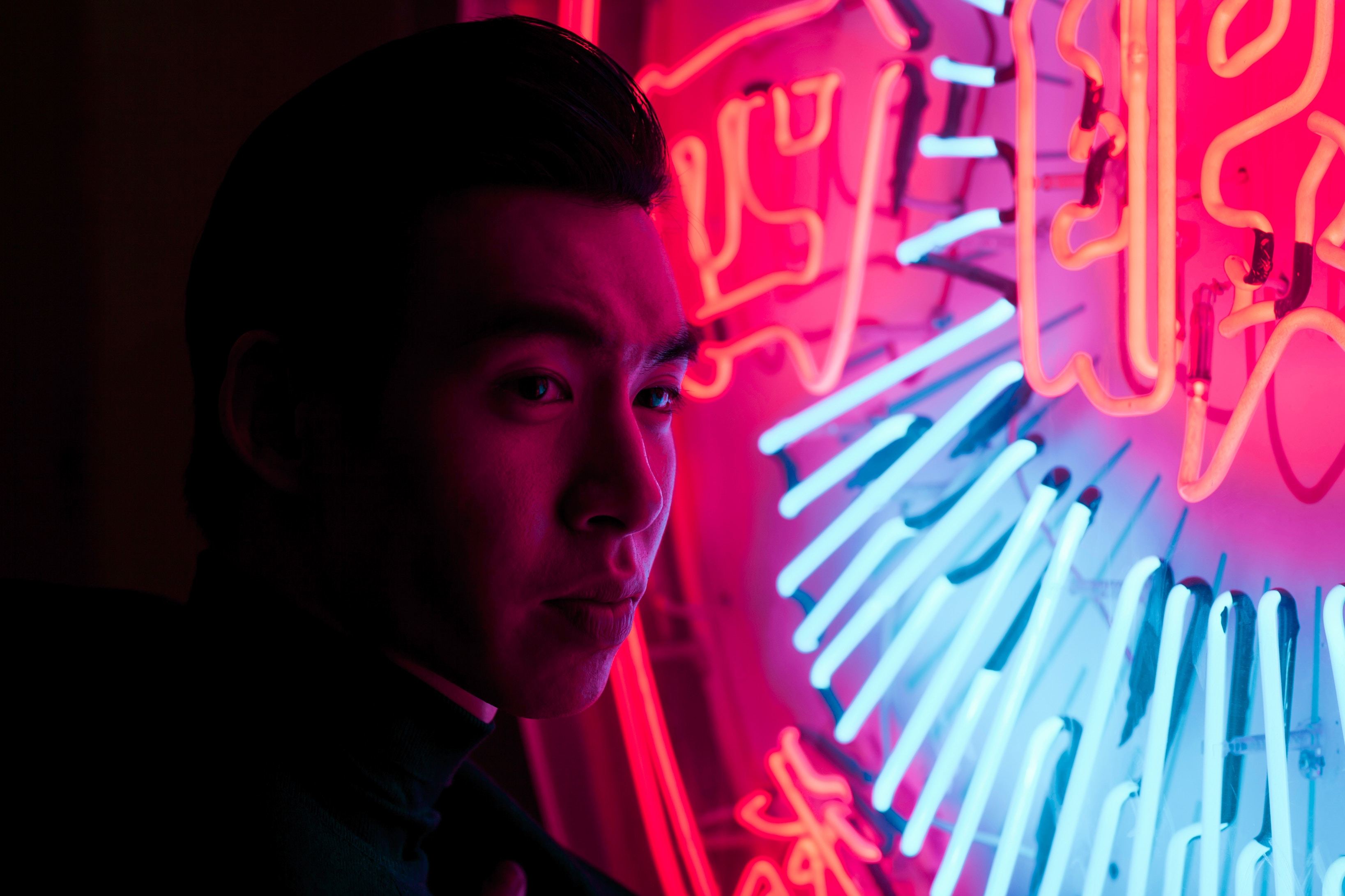 Young Chinese man with neon sign