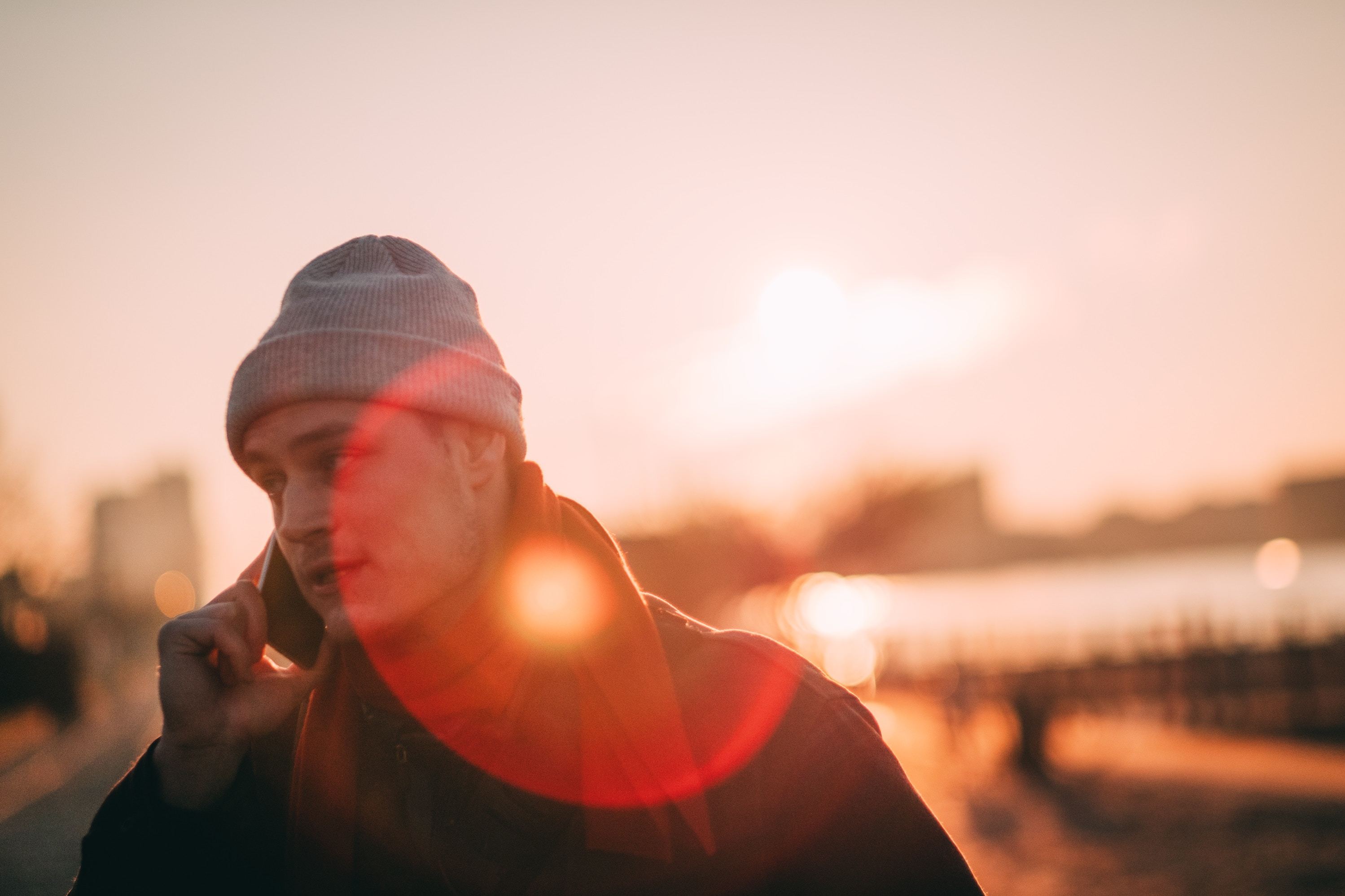 Man on phone with sunset behind him