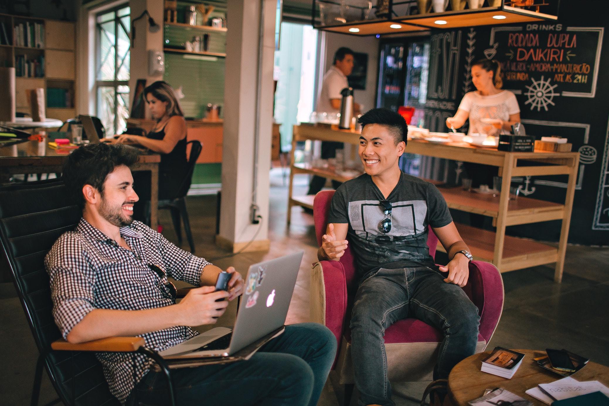 Men sitting on chairs having a chat in a coffee shop