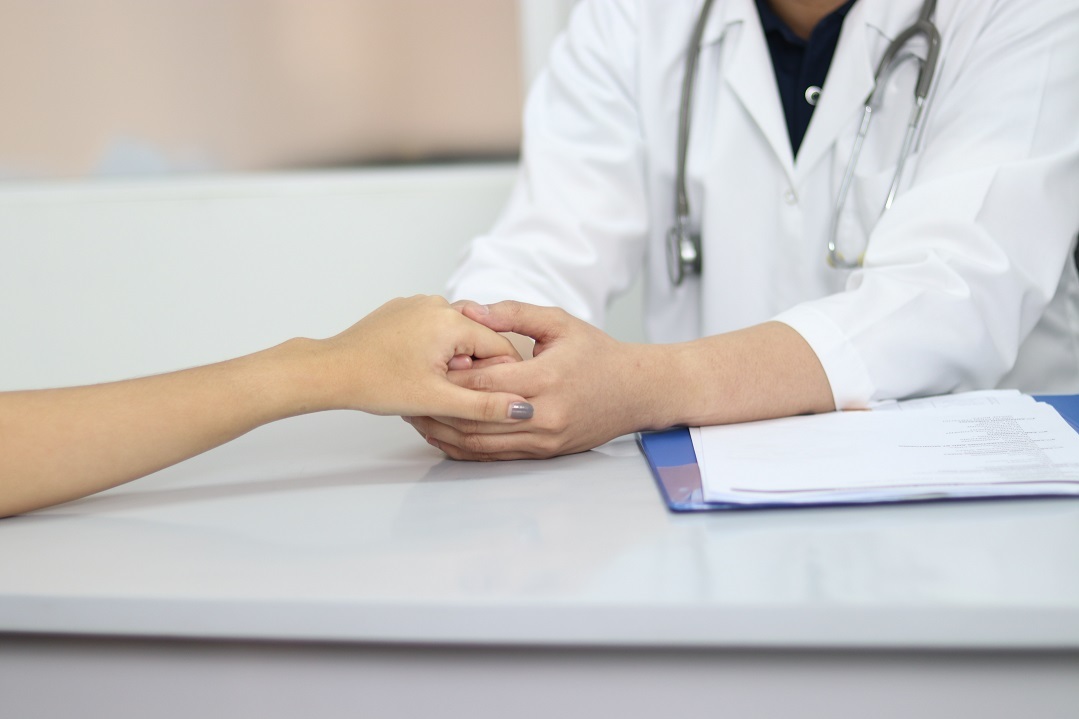 A doctor holding a patient's hand