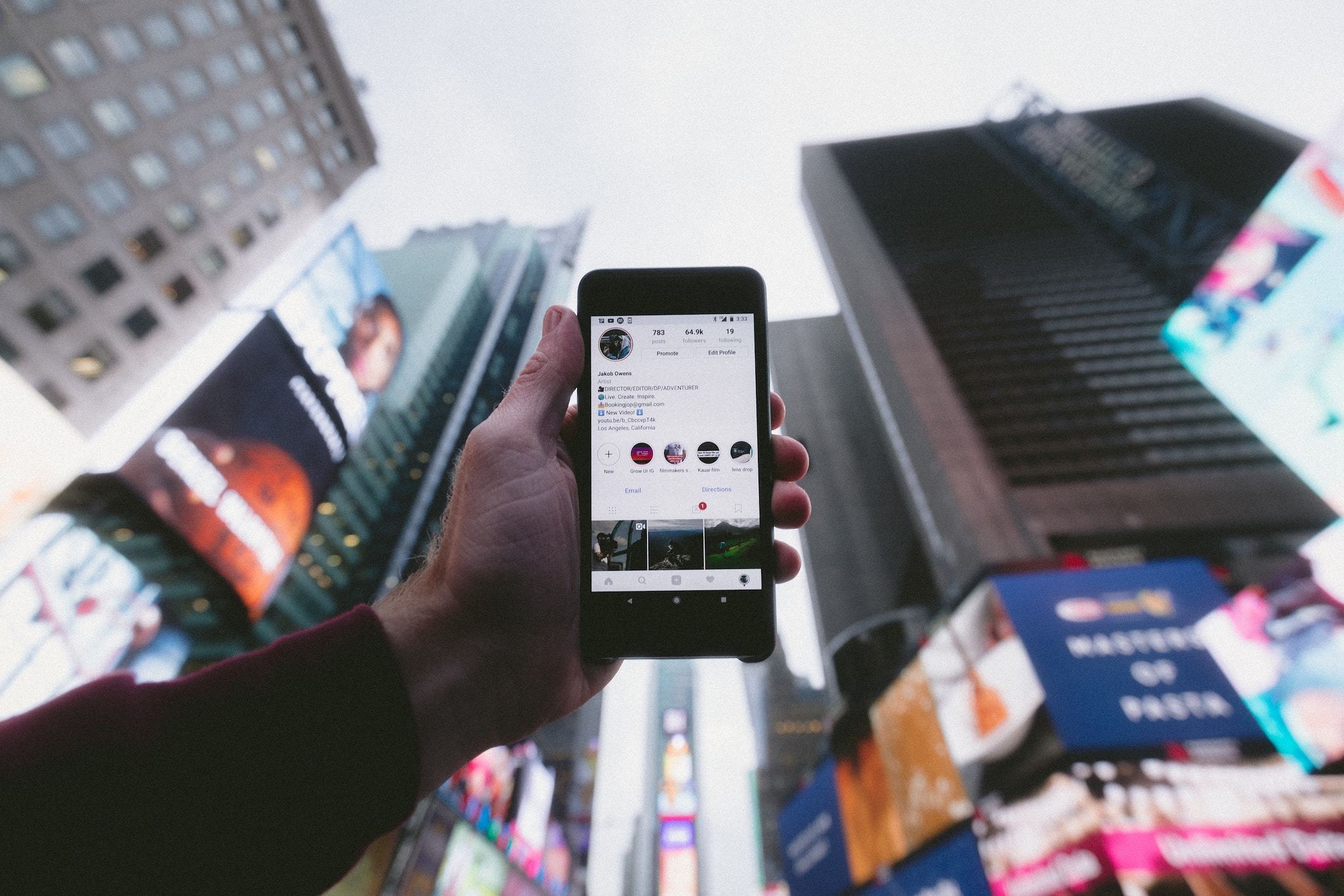 smartphone screen showing an Instagram account, background of a big city