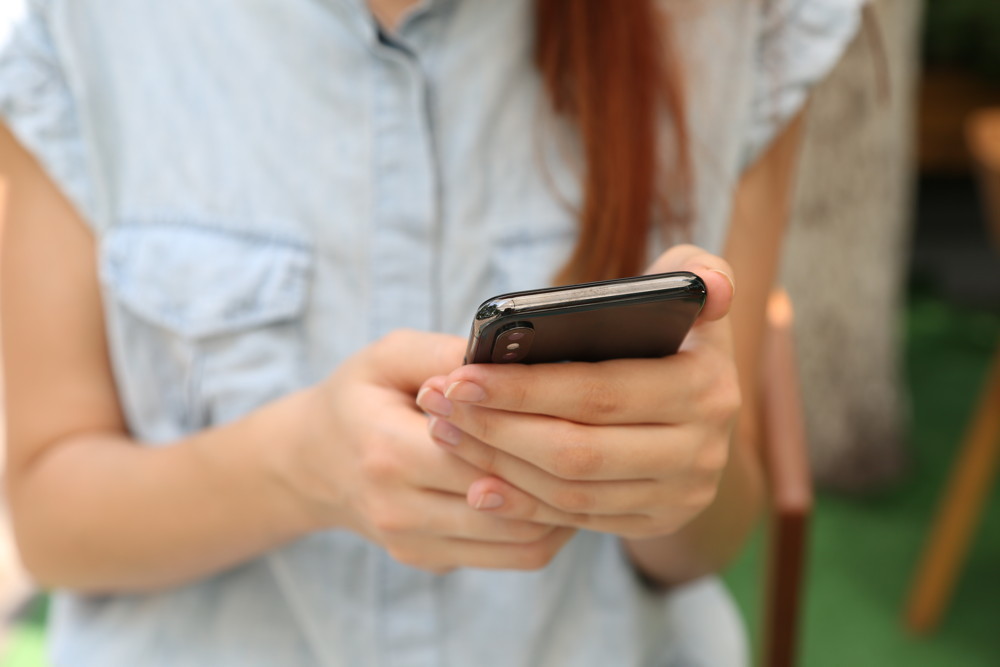 A woman accesses healthcare information on her smartphone.