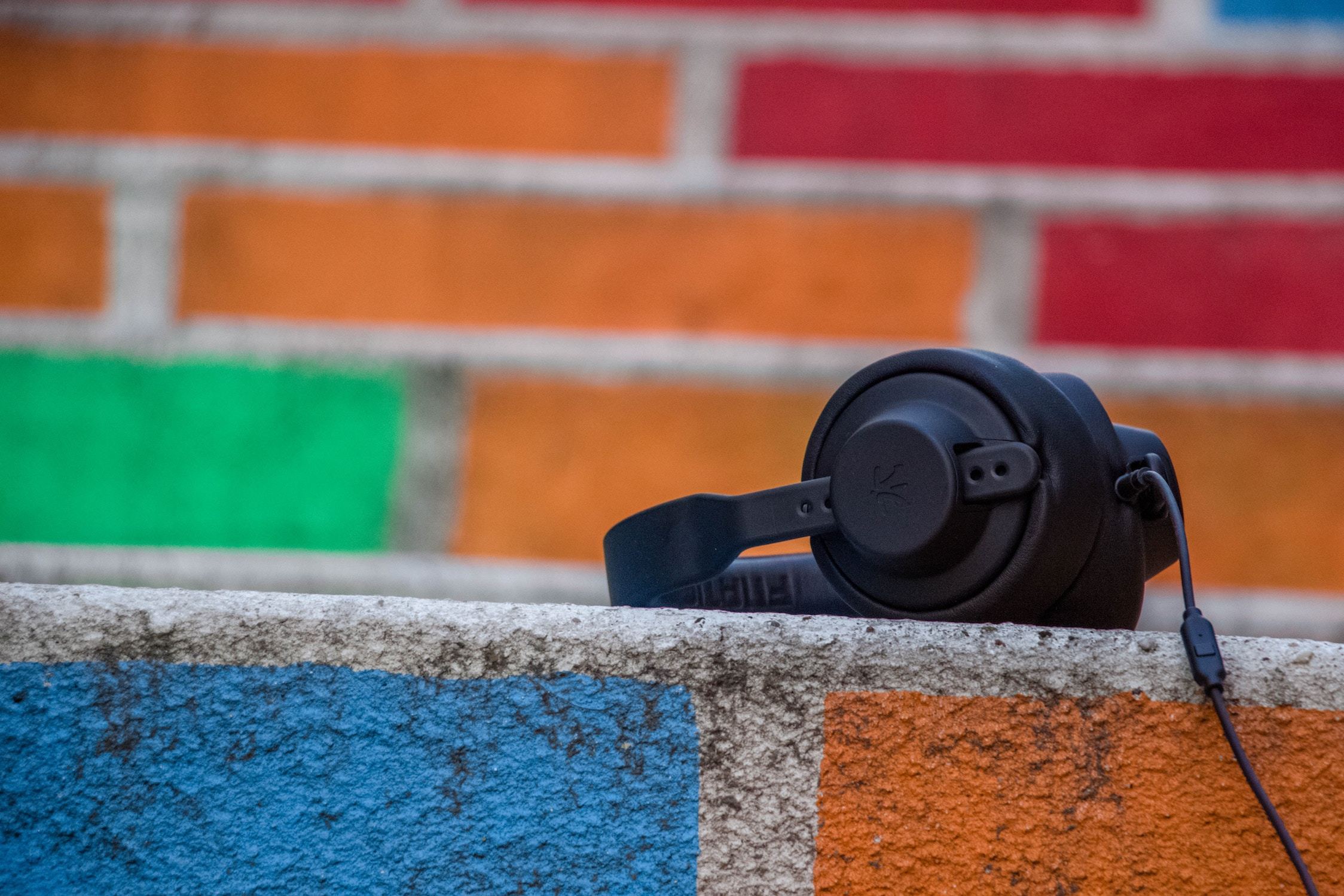 Headphones in front of a painted brick wall