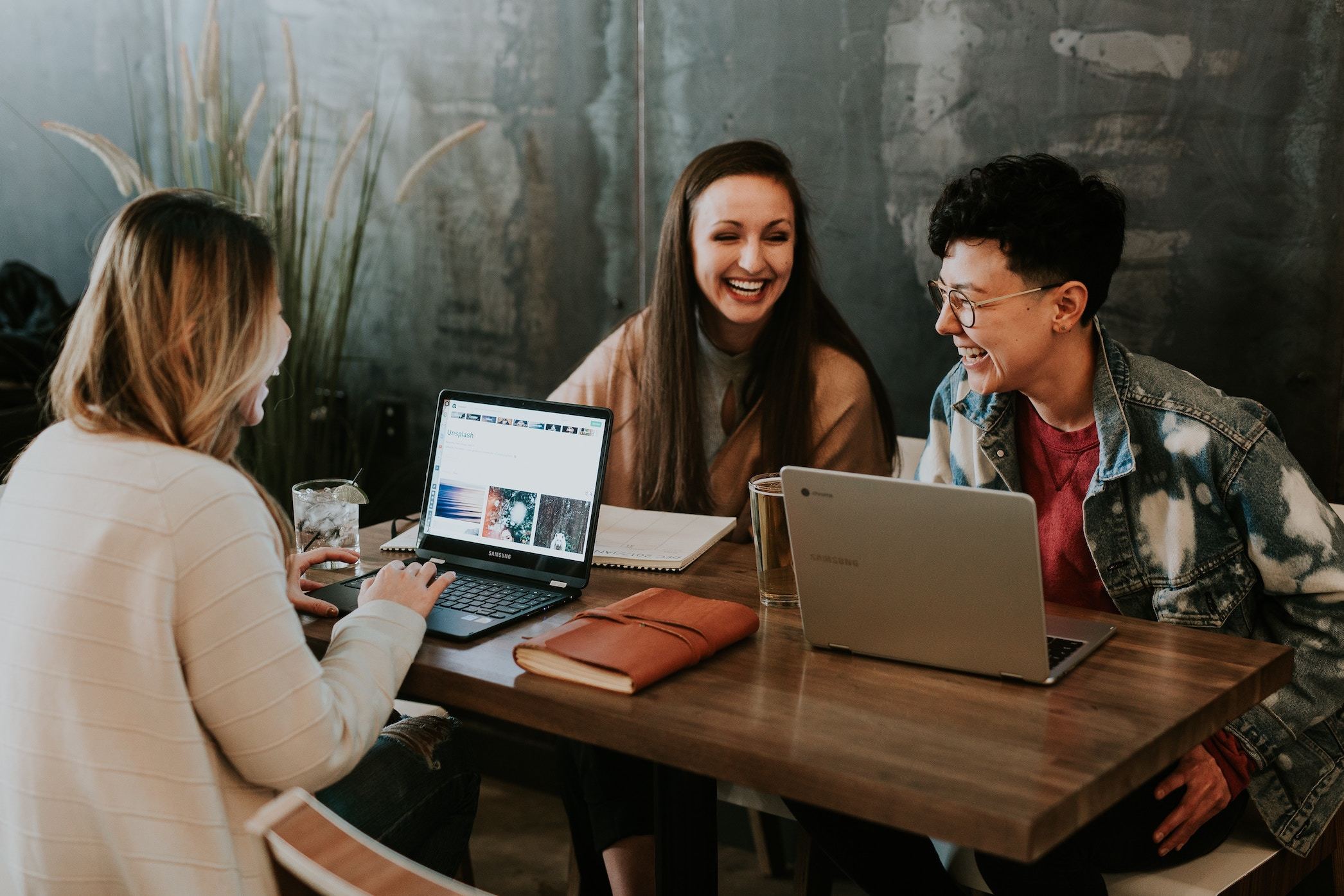 three women at a work table laughing