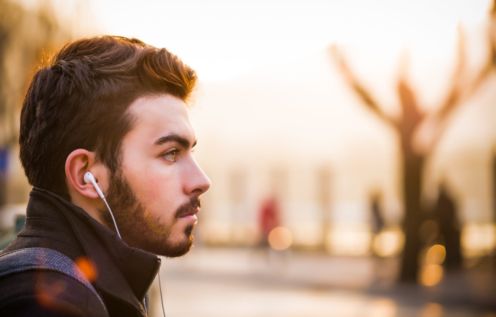 Man listening to a podcast with his smartphone while he stares off into the distance.