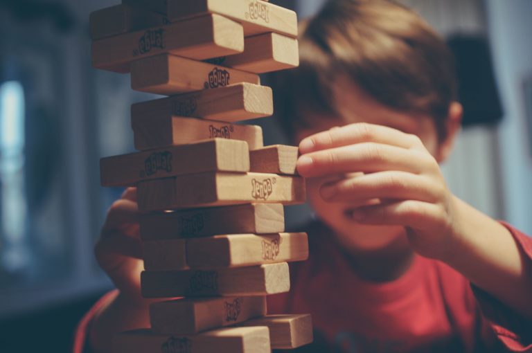 Boy plays with Jenga blocks.