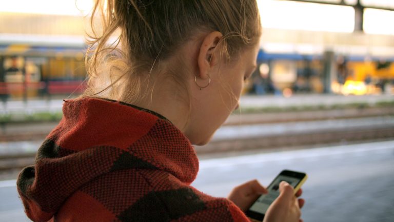 A woman looks at social media advertising on her smartphone.