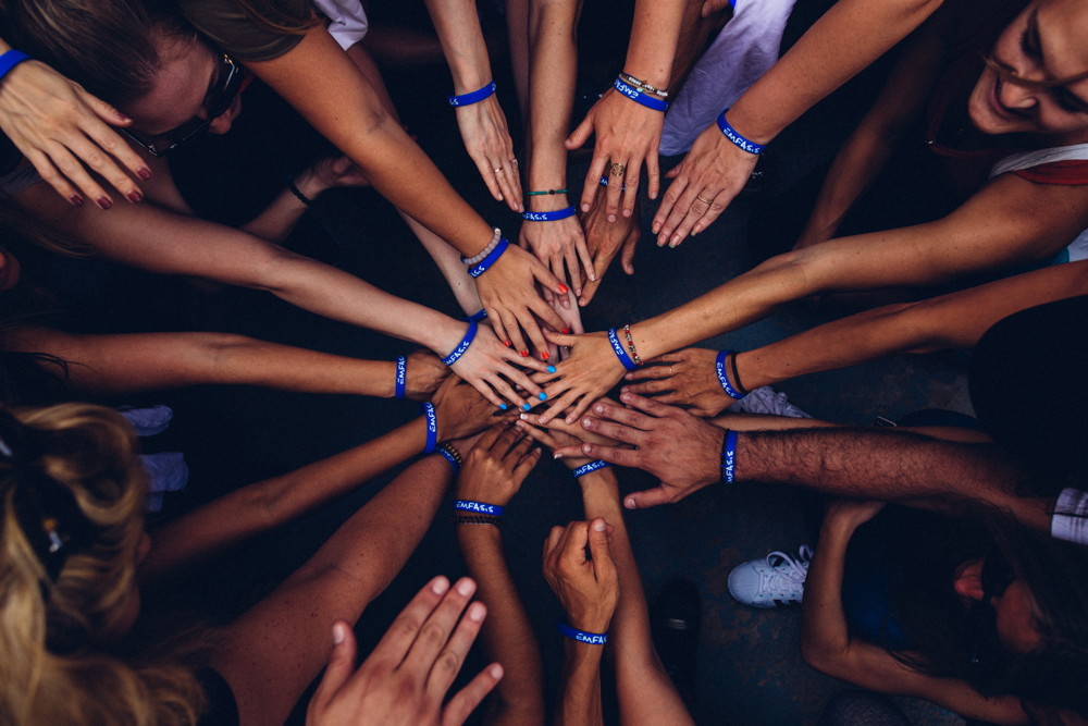 Members of a team putting their hands together to motivate one another.