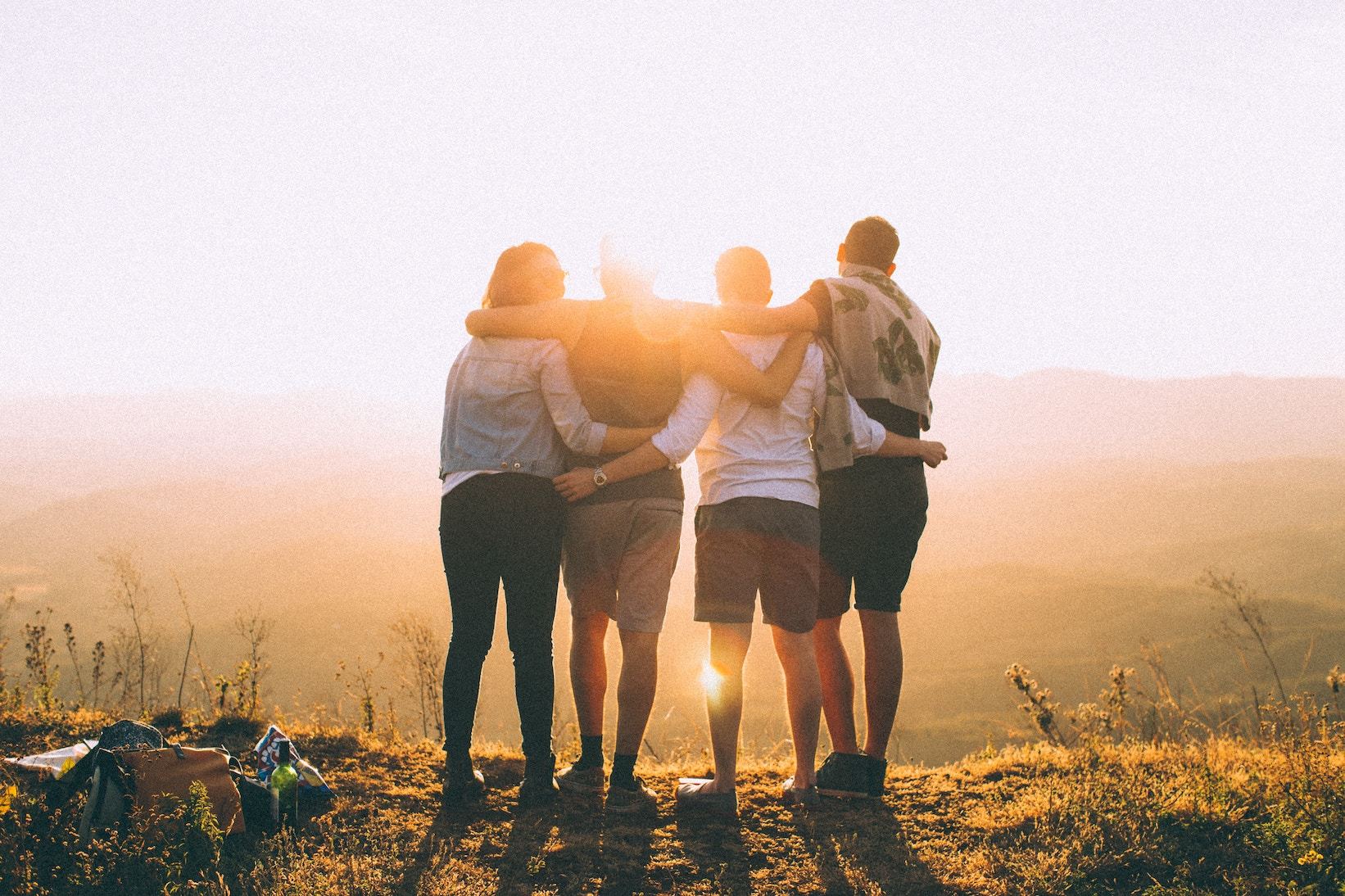 Four people with arms around each other