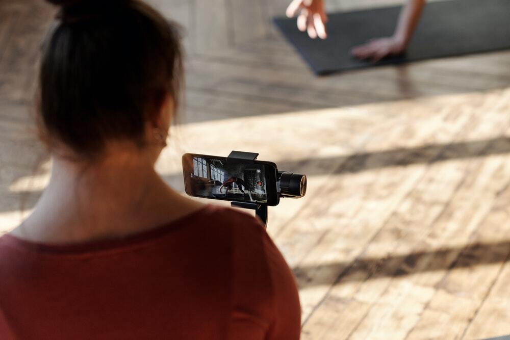 A woman records a video for a content marketing campaign using her iPhone.