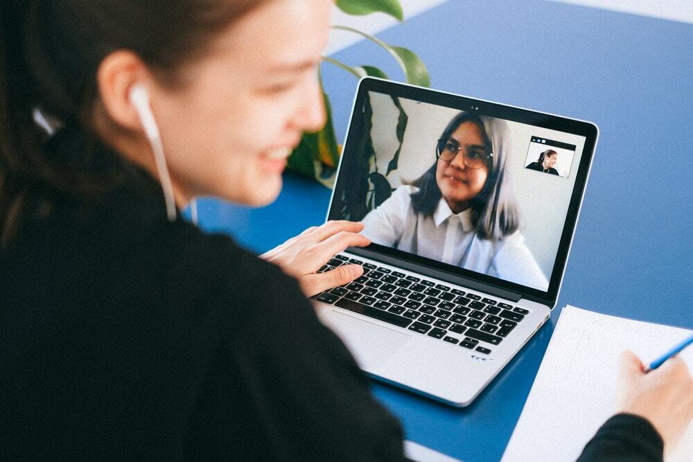 Two women have a video call to discuss their content marketing strategy.