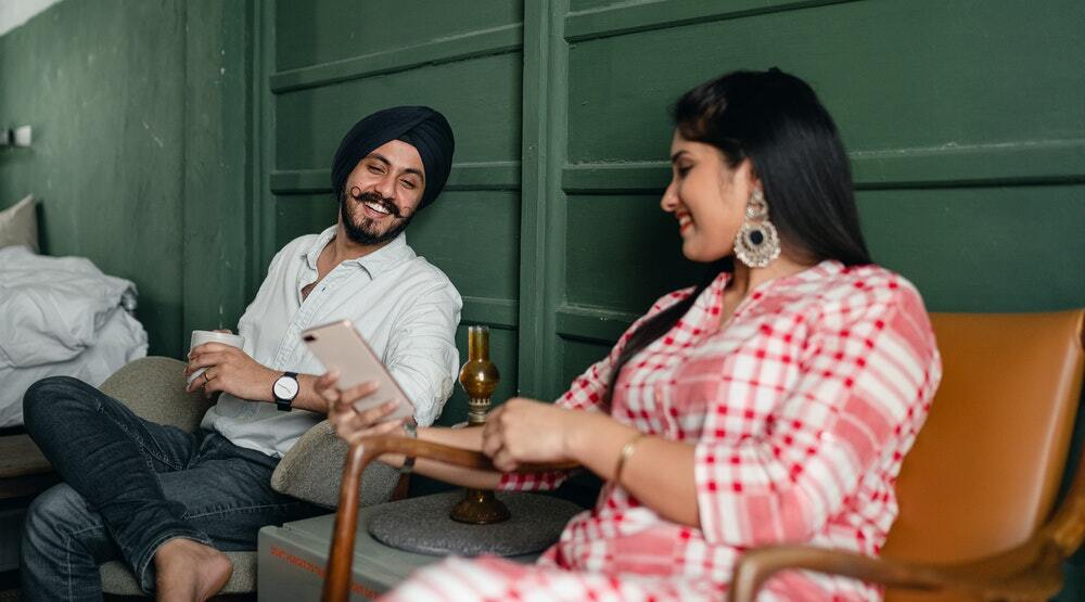 A couple laughs while looking at funny, quality content marketing on their smartphone.