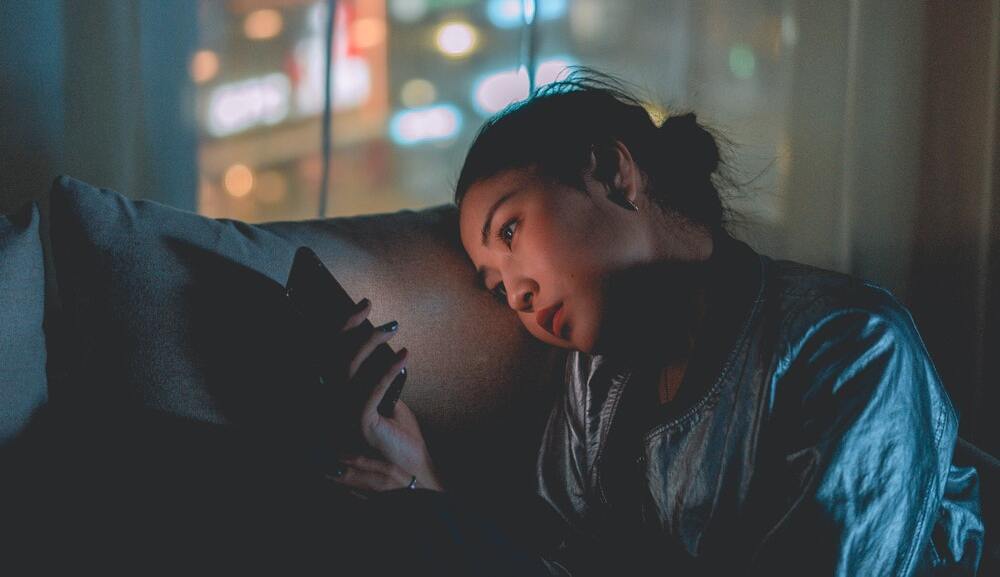 Woman using mobile phone to scroll through accessible social media content.