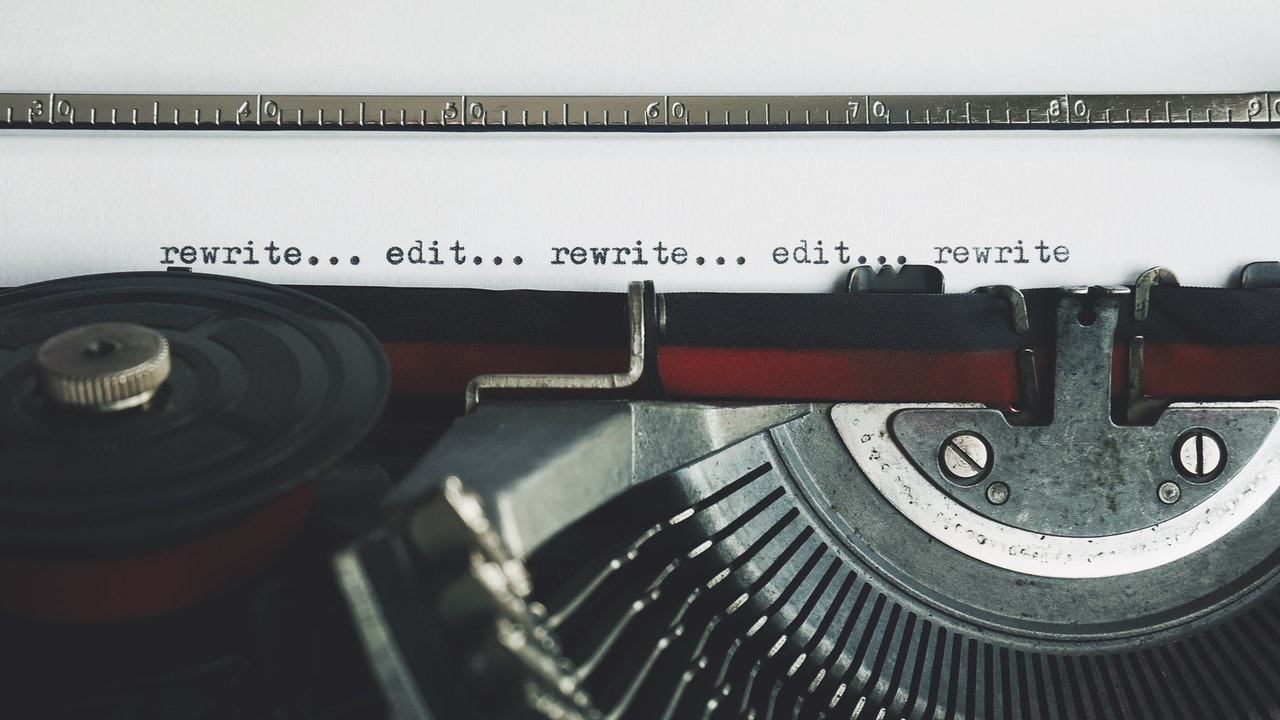 a close-up of a typewriter with the words rewrite and edit repeated multiple times