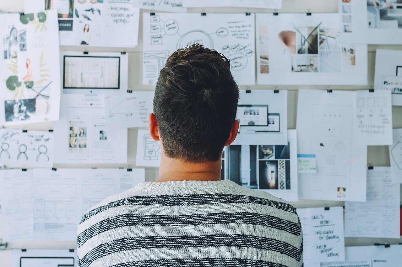 Person looking at wall of papers.